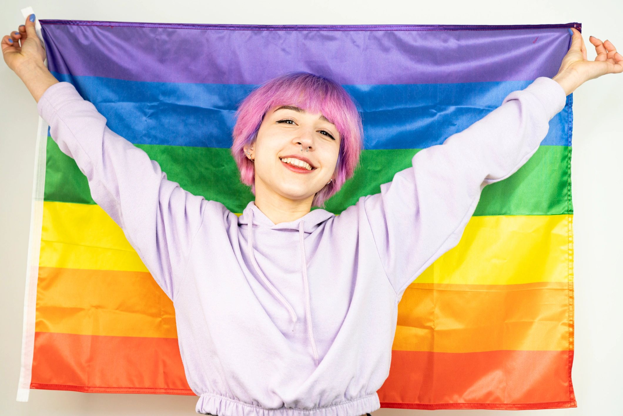 Hands holding a rainbow flag, representing inclusive community resources