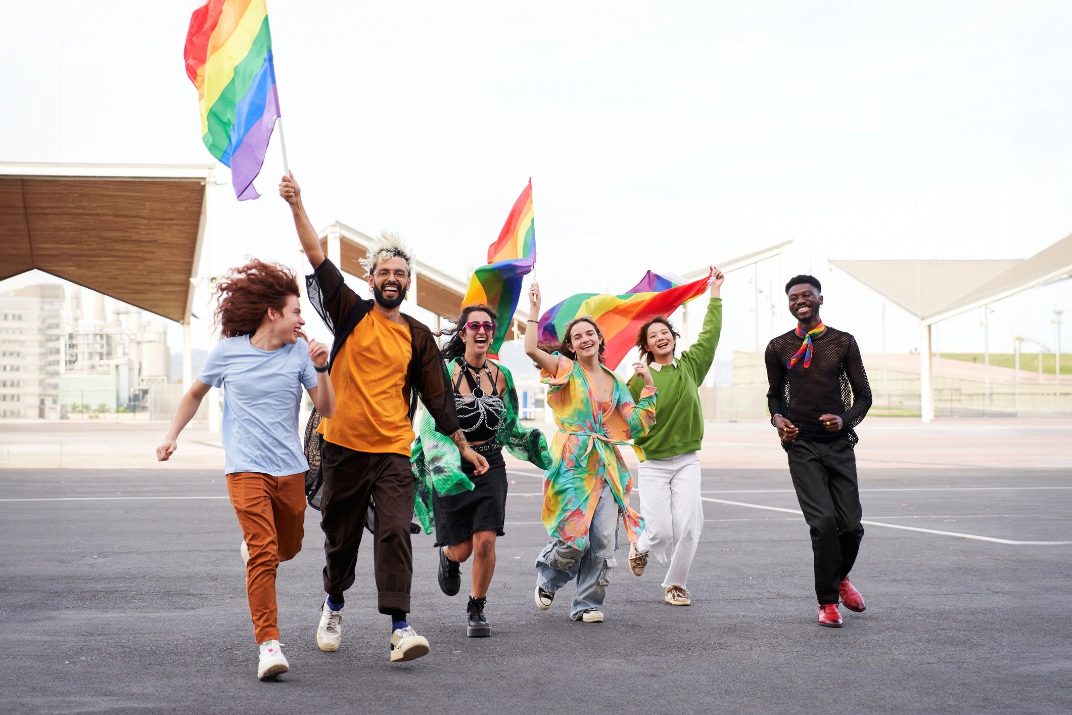 Group celebrating Pride holding rainbow flags outdoors