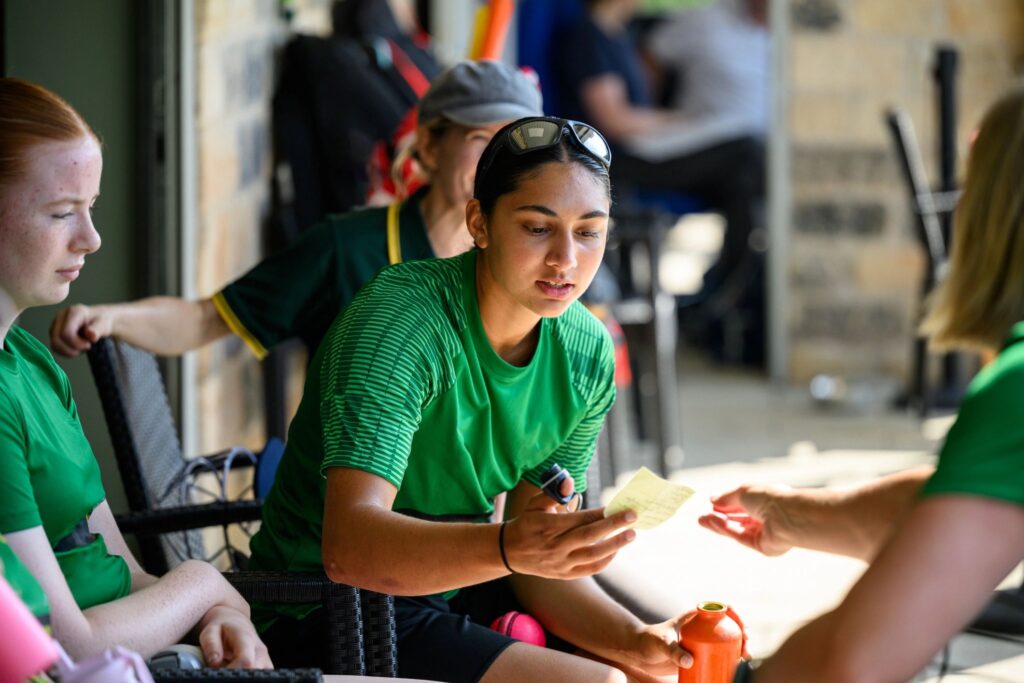 Team members reading notes on game strategy sitting together at the clubhouse before the game